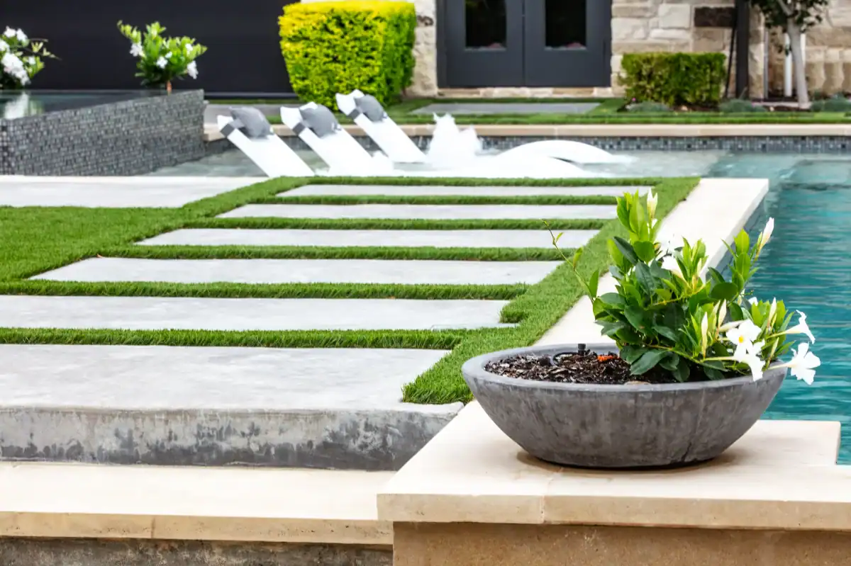 Artificial Turf strips around stepping stone pavers in an back yard oasis in Dallas Fort Worth