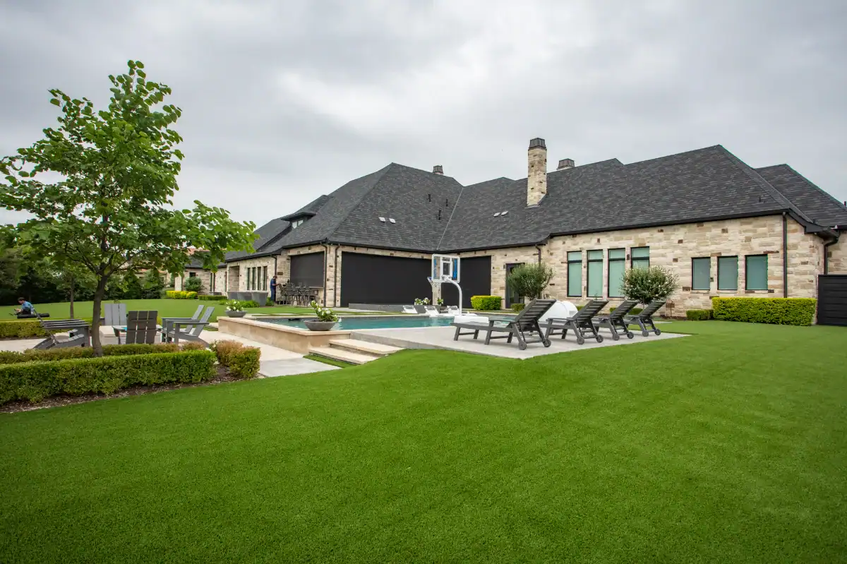 Large green artificial lawn turf installation with a pool and seating area in a Dallas Fort Worth suburb