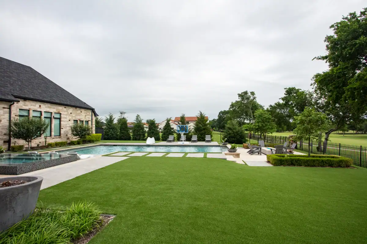 Artificial Grass Lawn in Fort Worth next to a golf course with a large pool and fire pit