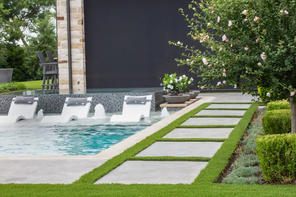 Artificial Turf Grids with pavers separating the pool from the flower beds