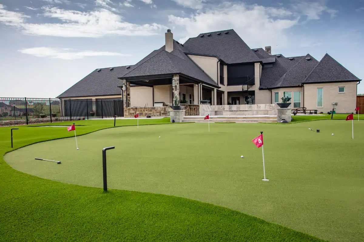 9 hole backyard butting green course with outdoor lighting and a volleyball court