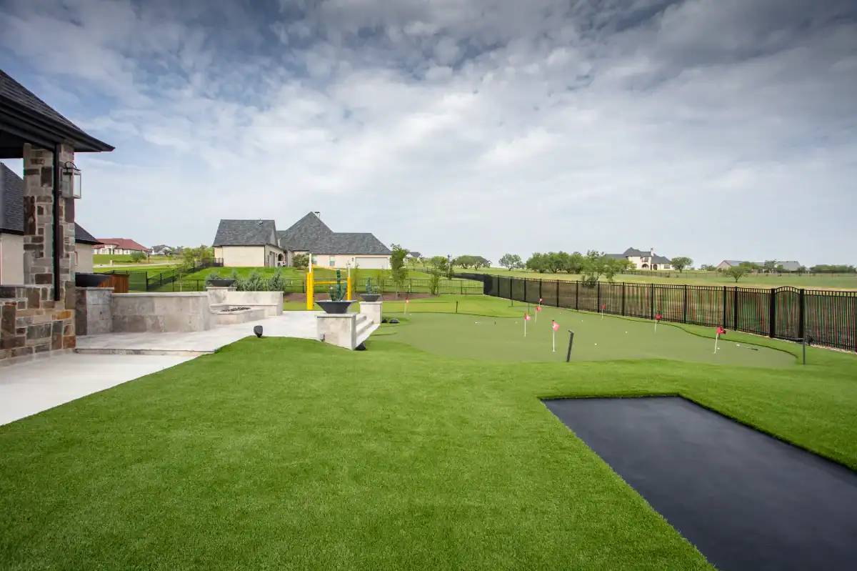 Putting Green in Highland Park Putting Green in Highland Park with an artificial grass lawn and an in ground trampoline