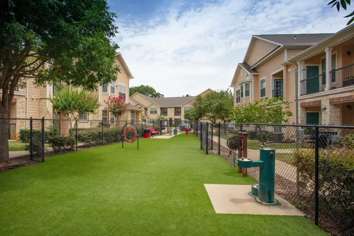 Artificial Turf Dog Park in an apartment complex with water fountains and dog equipment