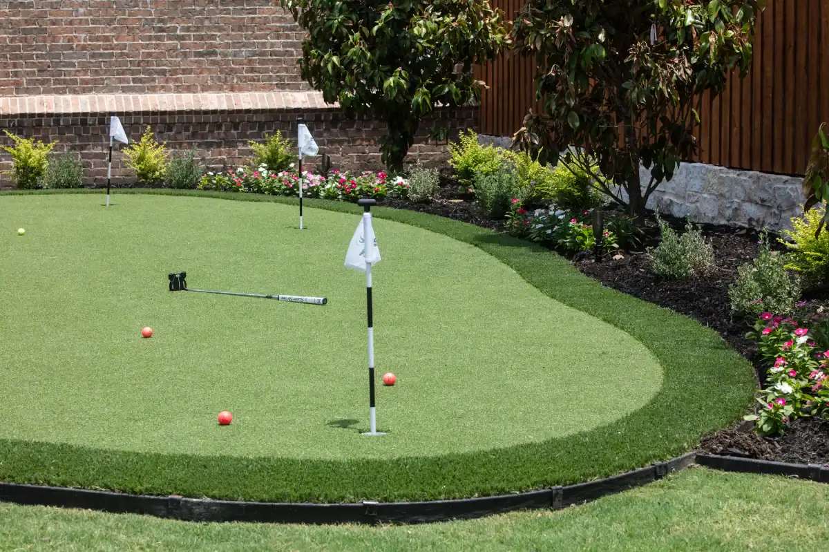Garland Putting Green Artificial Putting Green in Garland in a backyard with landscaping