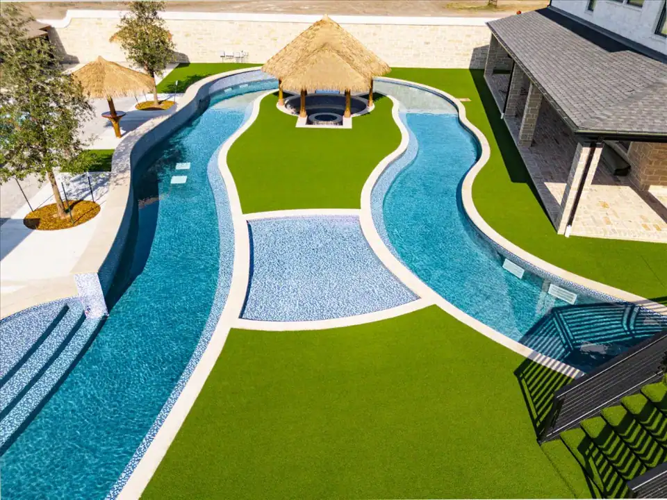 Artificial Grass Lawn in Addison with a travertine patio and a lazy river in a backyard
