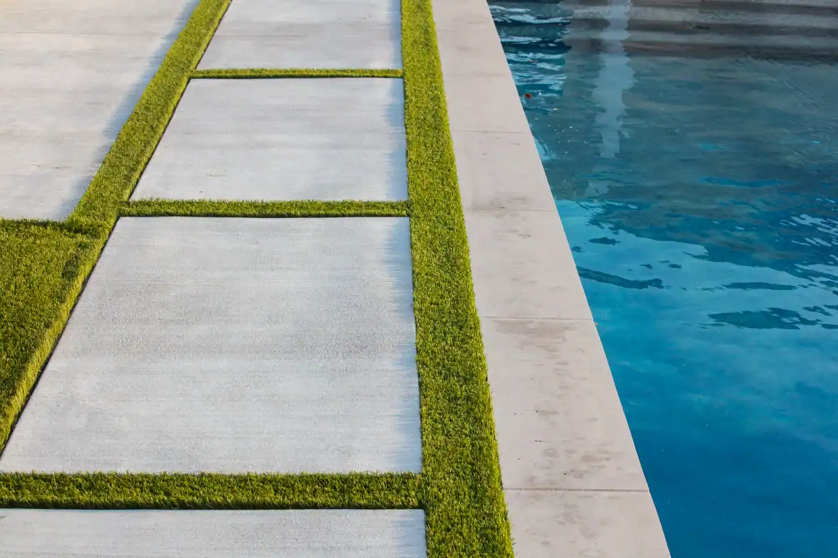 Artificial Turf and Paver Strips between a pool and patio