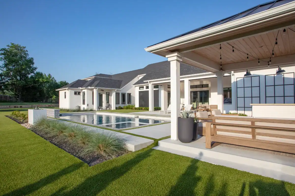 Lush artificial grass lawn with hardscaping around a pool and pergola in a Dallas Fort Worth neighborhood