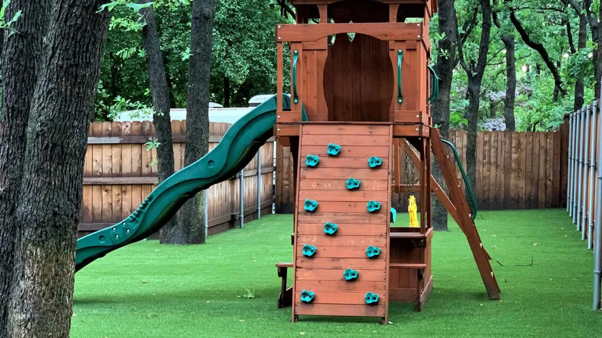 Backyard Playset with Artificial Grass Backyard Playset with Artificial Grass with a slide in a residential backyard